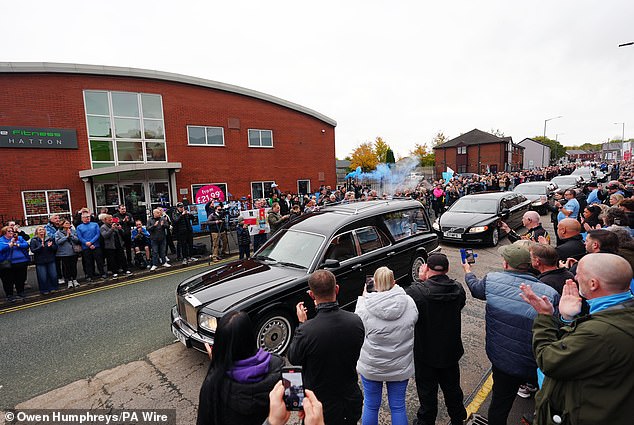 The cortege stops outside Hatton's Gym in Hyde during the procession this morning