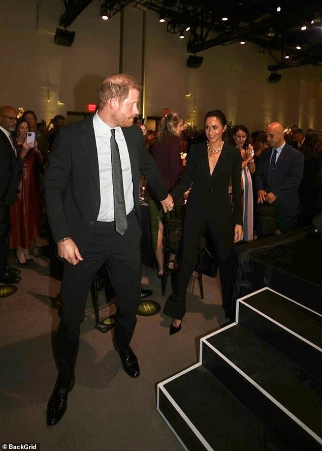 Harry and Meghan are applauded as they go on to stage