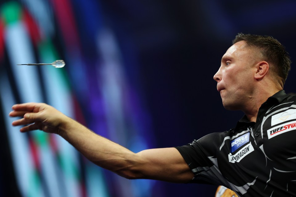 Gerwyn Price celebrates winning a leg during a darts match.