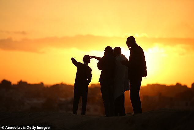 Some Palestinians walk on foot along Rashid Street, carrying the few belongings they manage to save, as they hope to go back to their homes after enduring harsh living conditions for months in Gaza City on October 10, 2025