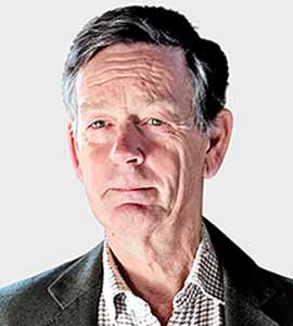 Headshot of a man with grey hair wearing a collared shirt and jacket.