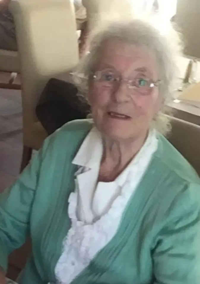 Joan Green, a frail widow, wearing glasses and a green cardigan.