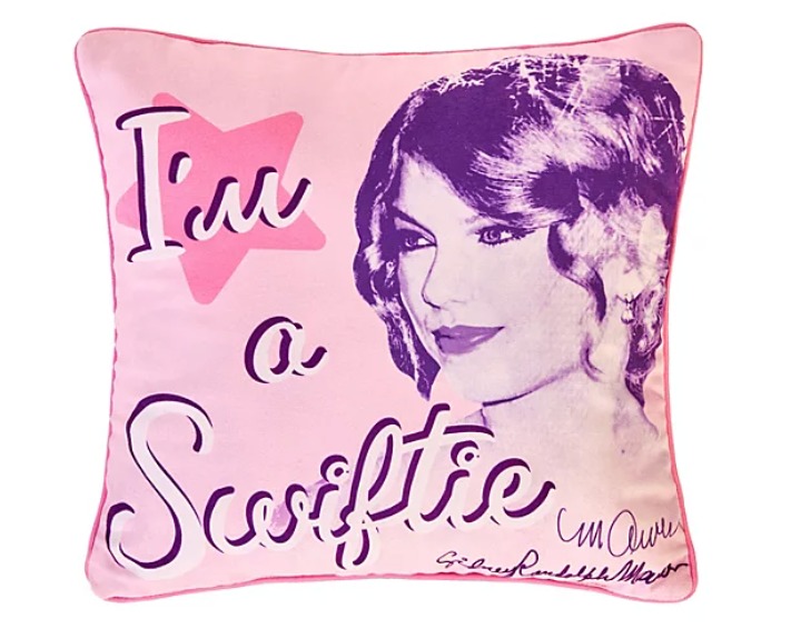 Pink cushion with "I'm a Swiftie" text and a purple illustration of Taylor Swift.