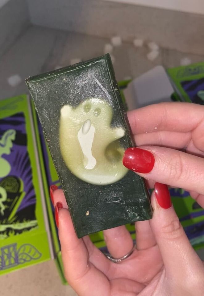 Hands holding a green soap bar with a light green ghost shape on it.