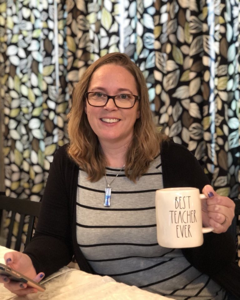 Carrie Henn holding a mug that says "Best Teacher Ever."