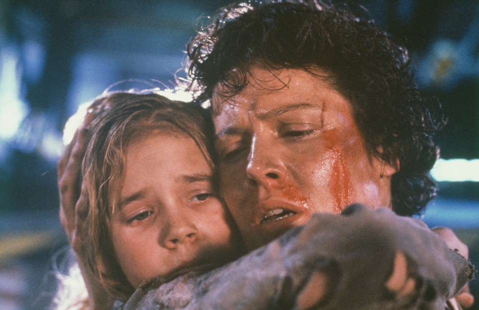 Sigourney Weaver as Ripley and Carrie Henn as Newt in a close embrace.