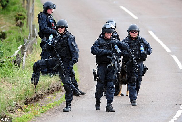 Armed police in Rothbury, Northumberland, during the stand-off with Moat in July 2010