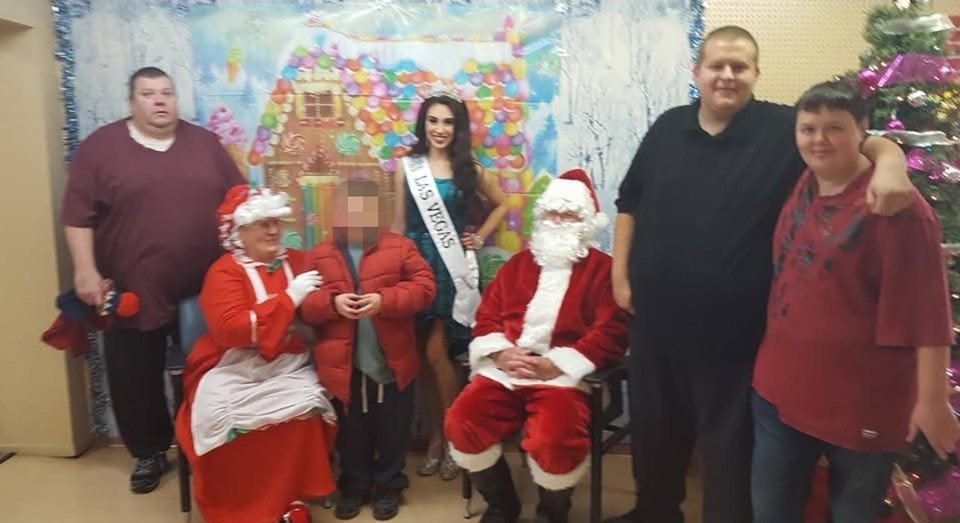 People in costumes with a Miss Las Vegas title winner at a holiday event.