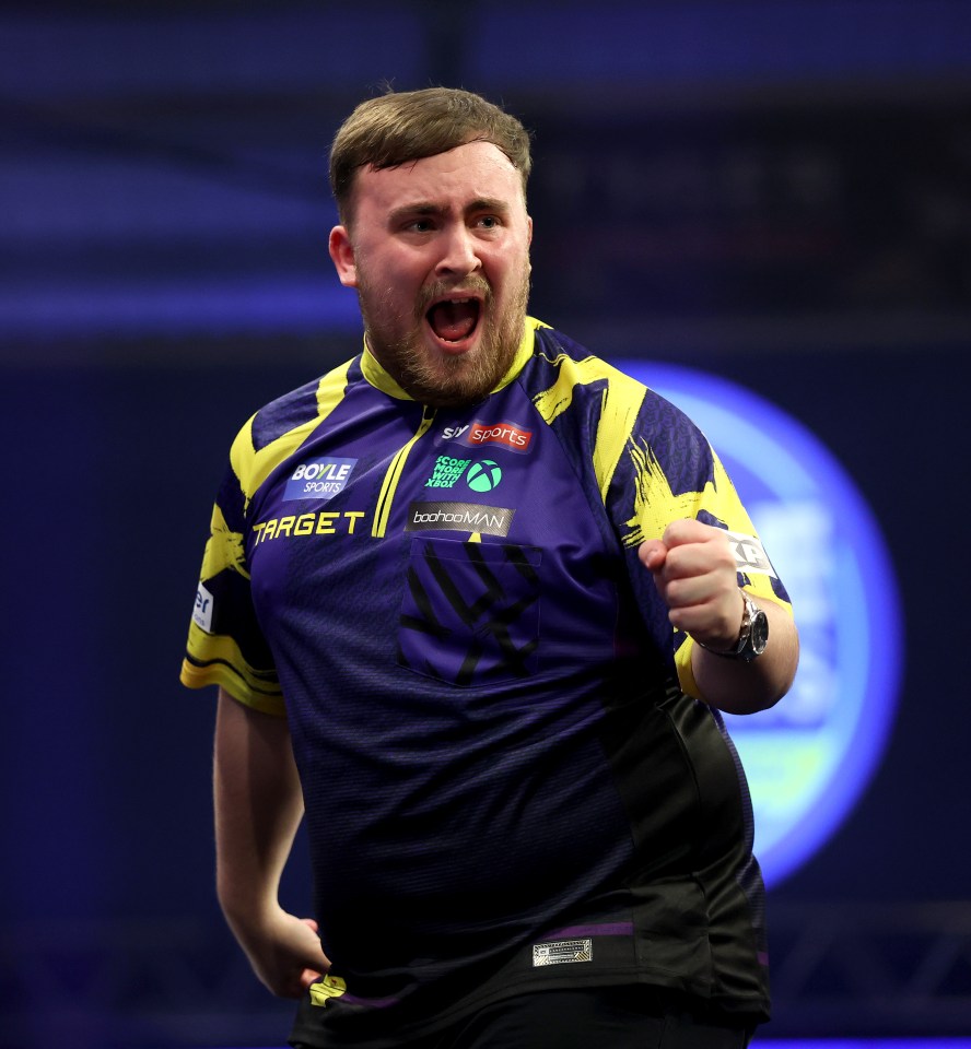 Darts player Luke Littler clenching his fist, shouting, and celebrating during his quarter-final match.