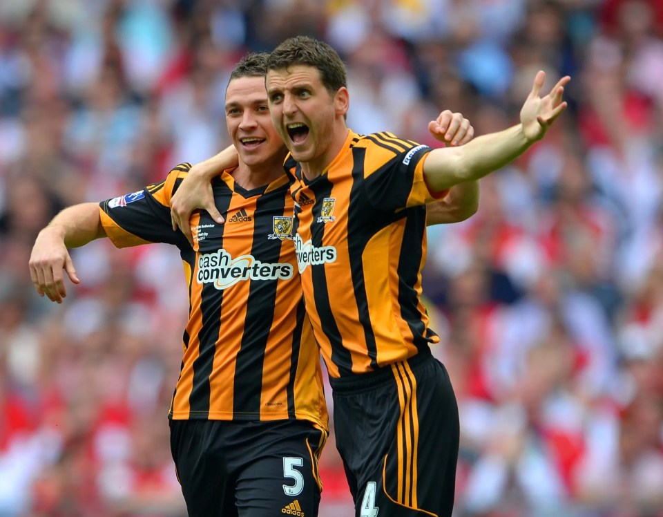 Two soccer players from Hull City, James Chester and Alex Bruce, celebrate a goal.