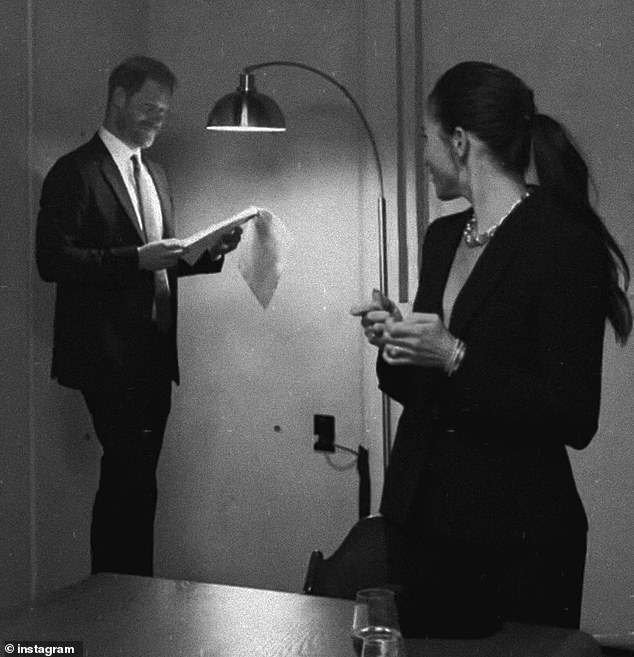 Meghan could be seen laughing at something Harry told her as he looked over papers next to a lamp - seemingly proving there was no awkwardness between them