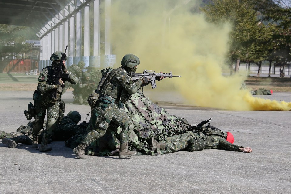 Taiwanese soldiers holding firearms during a military inspection.