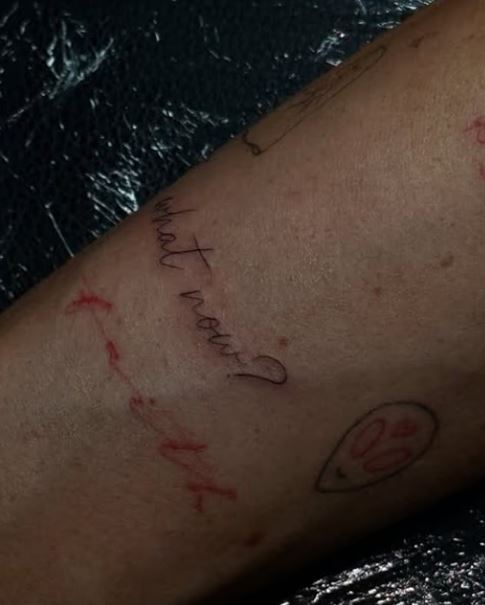 Close-up of a new tattoo on Olivia Attwood's arm, reading "what now?"