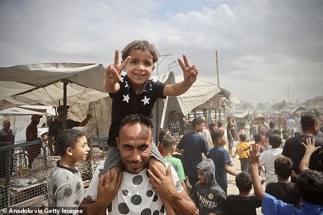 Palestinians, including children, gathered in the city of Khan Yunis celebrate after the announcement of the ceasefire agreement in Gaza on October 09, 2025 in Khan Yunis, Gaza