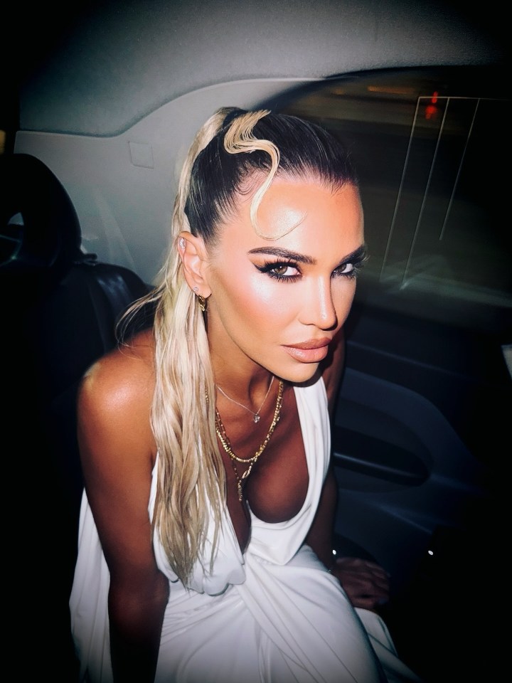 Christine McGuinness posing in a white dress in a car.