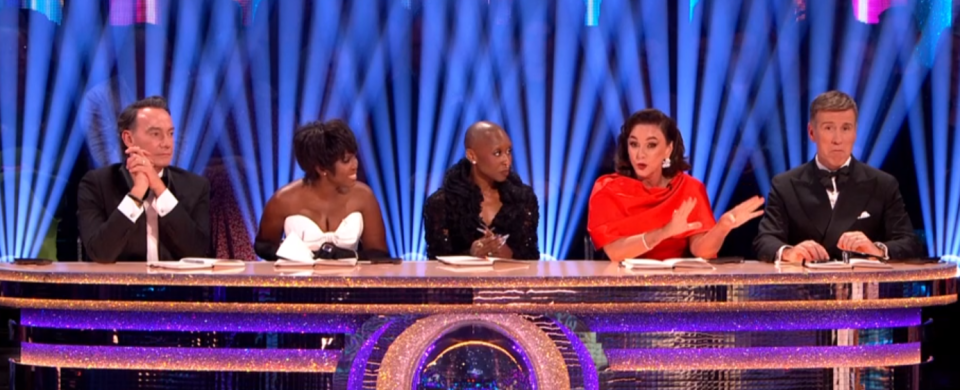 Five judges at a glittery desk.