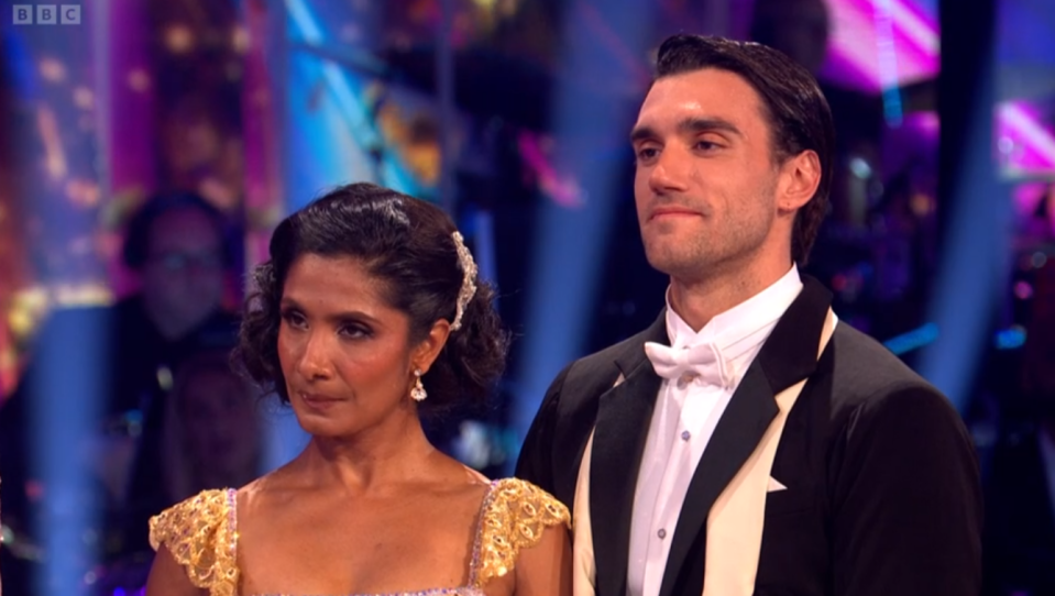 A male and female dancer on a brightly lit stage.