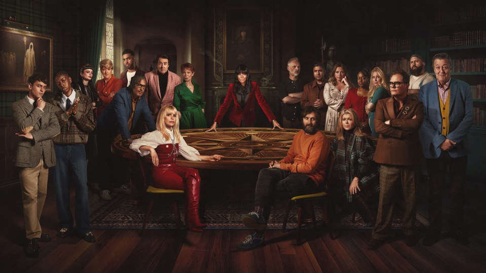 The cast of BBC1's The Celebrity Traitors gathered around a wooden table.