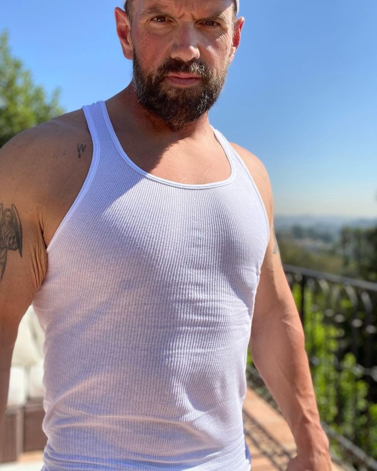 Ethan Suplee shows off his muscles and six-pack abs in a white tank top.
