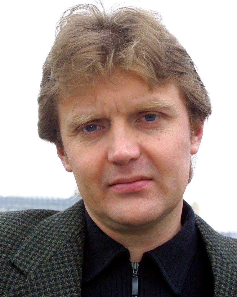Alexander Litvinenko, a man with blonde hair and blue eyes, looks toward the viewer.