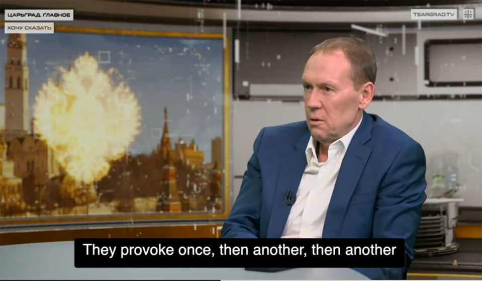 Andrey Lugovoy, a Russian MP, in a blue suit and white shirt, speaks during a broadcast with a background showing the Kremlin and an explosion, with the words "They provoke once, then another, then another" at the bottom.