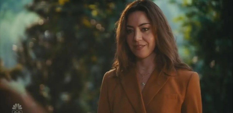 Aubrey Plaza as April Ludgate smiling with a green background.