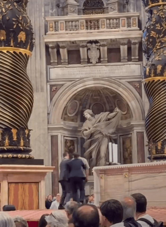 Security guards apprehending a man who urinated on an altar at St. Peter's Basilica.