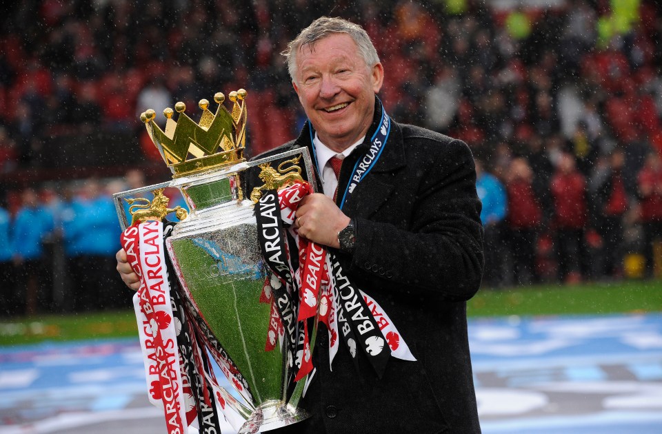 Sir Alex Ferguson holding the Premier League trophy.