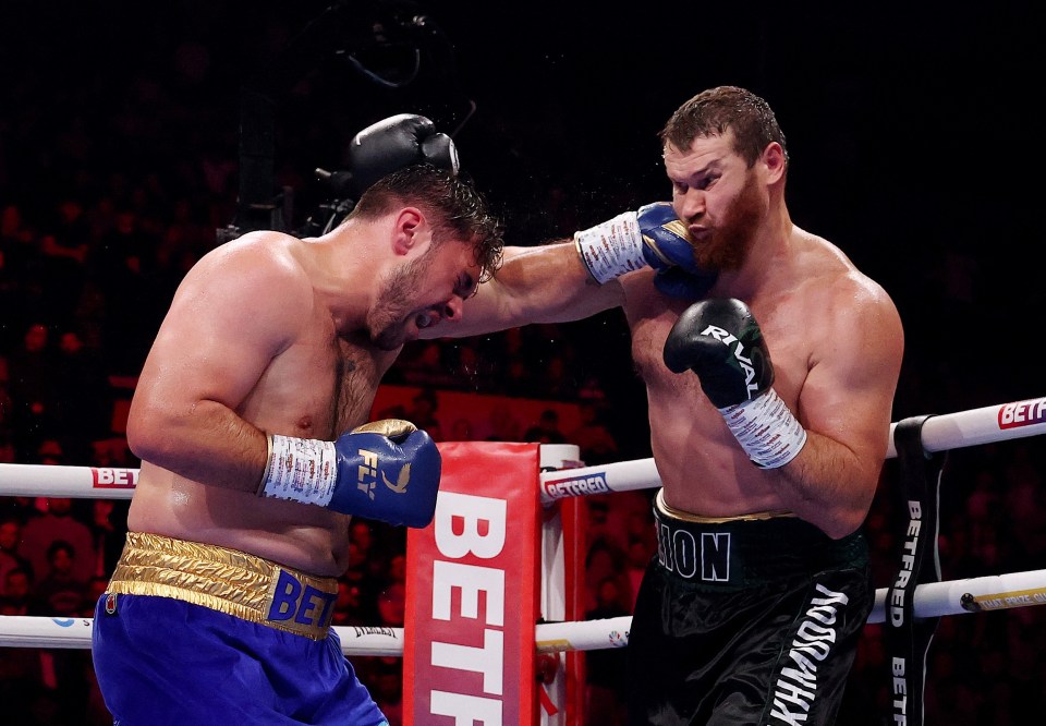 Dave Allen taking a punch from Arslanbek Makhmudov during their boxing match.