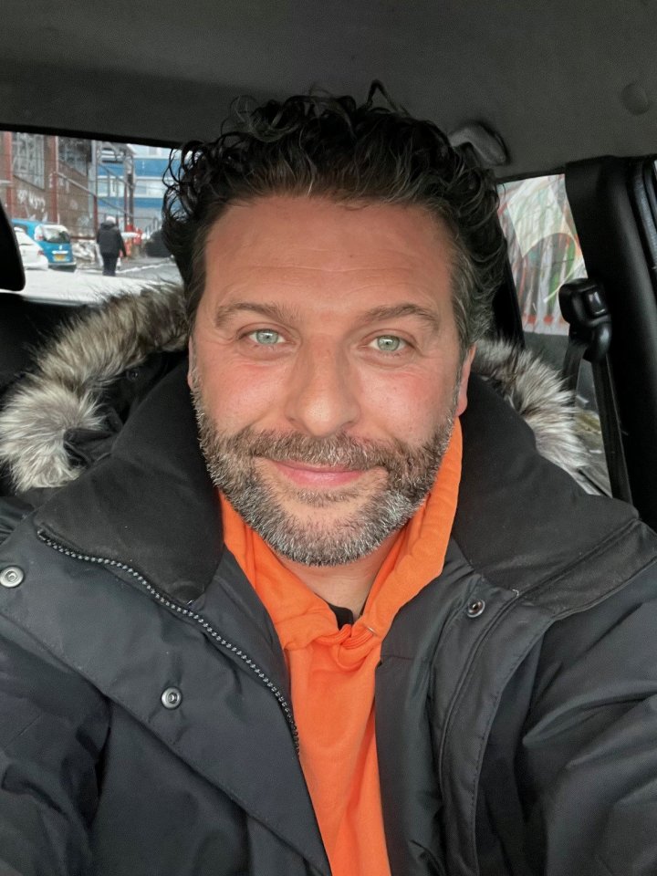Daymon Britton, actor from Byker Grove, wearing an orange hoodie and black parka.