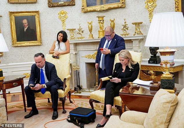Katie Miller, wife of White House deputy chief of staff for policy Stephen Miller listens, as White House Press Secretary Karoline Leavitt, White House Deputy Chief of Staff Dan Scavino and White House Communications Director Stephen Cheung look at their smartphones during a press conference with U.S. President Donald Trump and Elon Musk, in the Oval Office at the White House in Washington, D.C., U.S., May 30