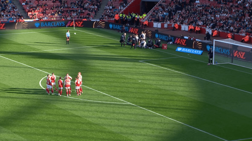 Football players gather around a teammate who is injured on the field.