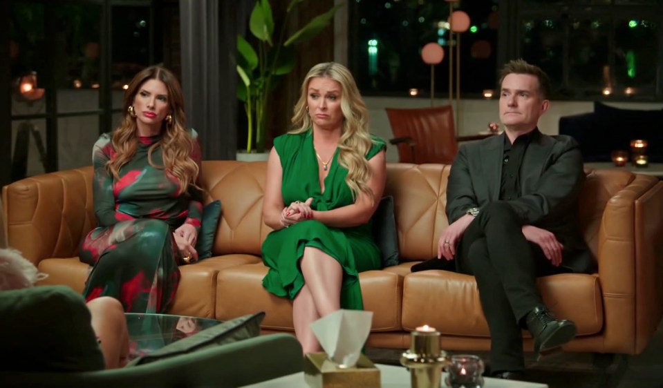 Awhina, Adrian, and another cast member from Married at First Sight sitting on a brown couch.