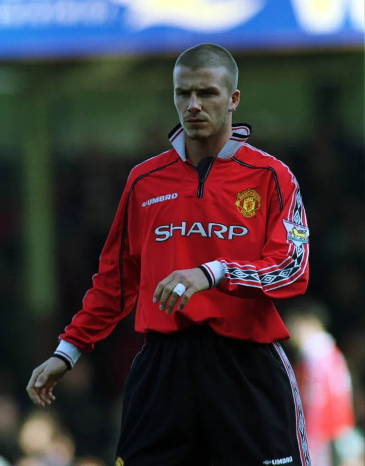 David Beckham in a red Manchester United jersey with a new haircut, during a match against Leicester City.