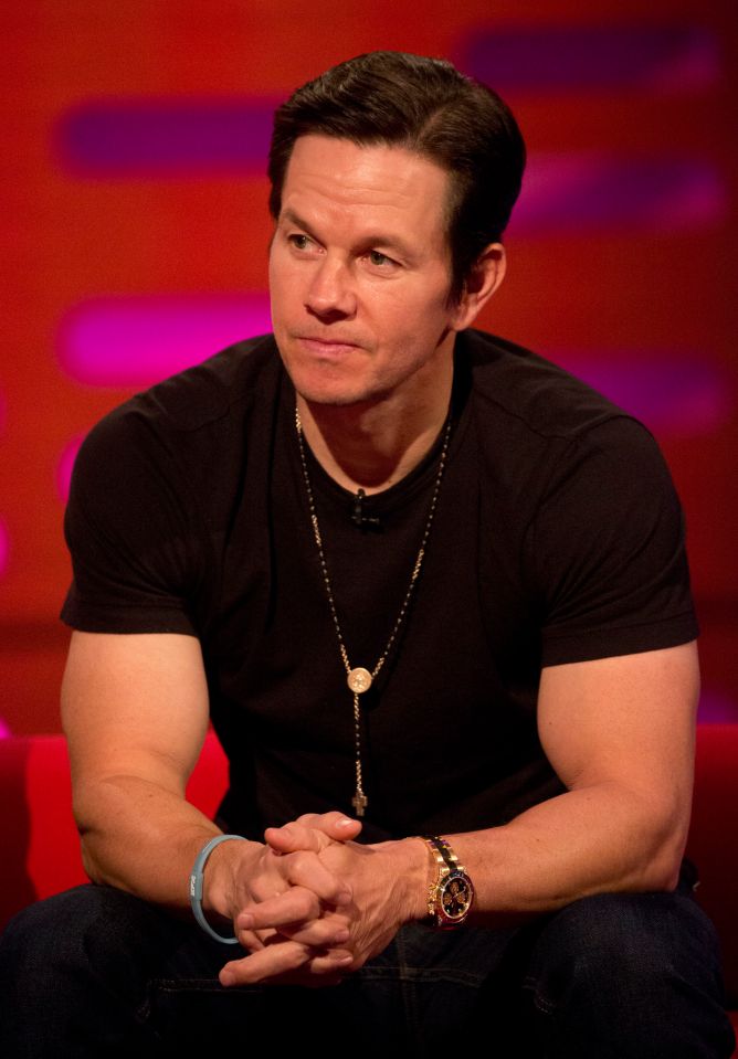Mark Wahlberg on the Graham Norton Show, wearing a black shirt, jeans, and a rosary necklace.