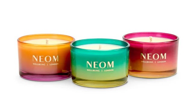 Three colorful Neom Wellbeing London candles.