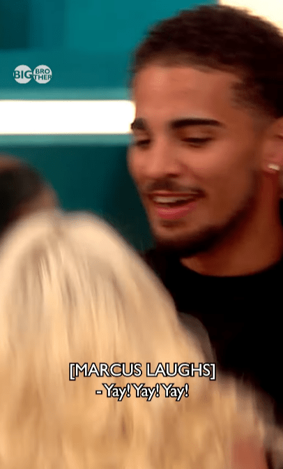 Marcus laughing and saying "Yay! Yay! Yay!" while looking at someone with blonde hair.