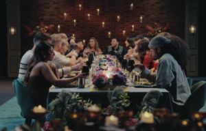 An image collage containing 1 images, Image 1 shows A group of people sitting at a long dinner table with a floral centerpiece