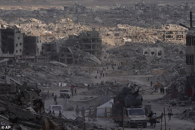 Palestinians walk among destroyed buildings in Gaza City on Sunday, October 12, 2025