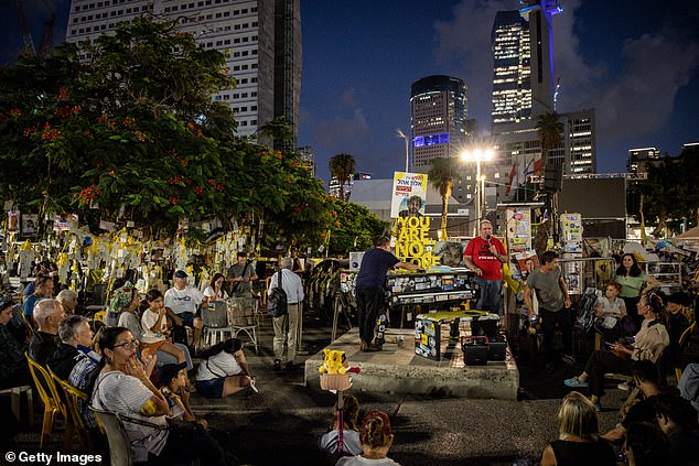 People listen to songs played on a piano at Hostages Square on October 12, 2025 in Tel Aviv, Israel