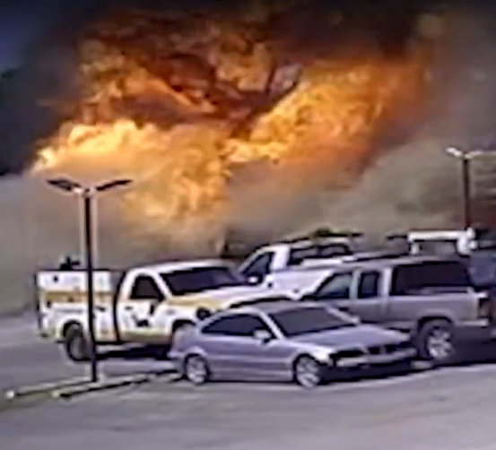 Parking lot with cars engulfed in flames.