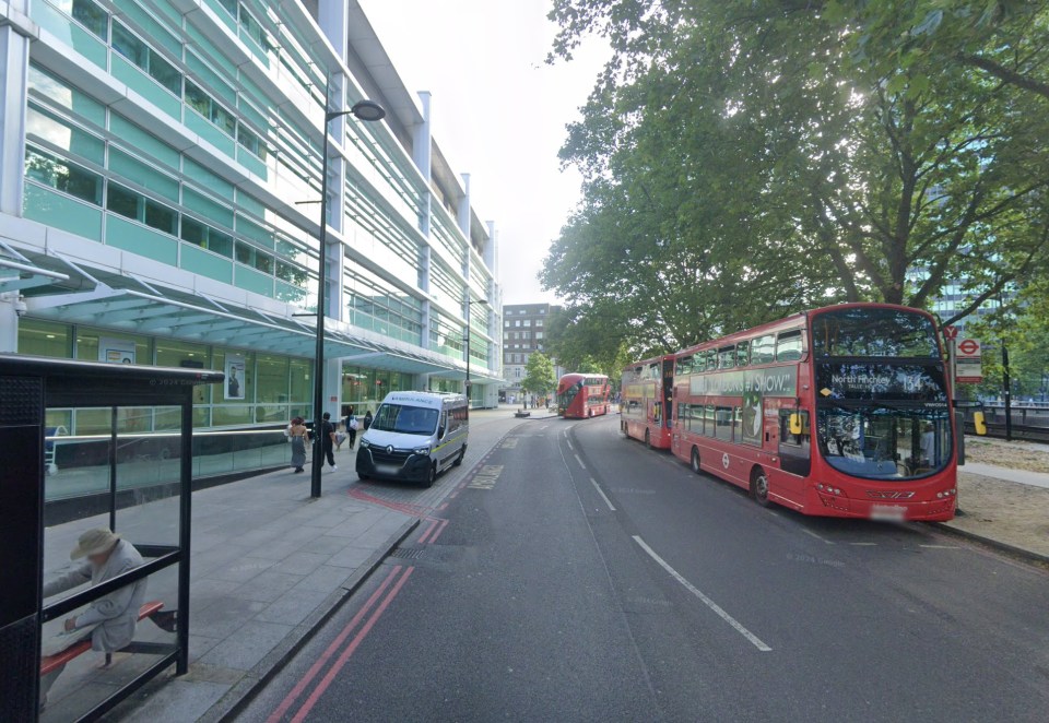 Euston Road with red double-decker buses and an ambulance parked by a modern building with green-tinted windows.