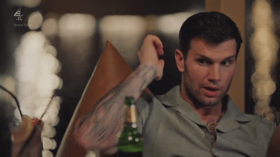 A man with tattoos on his arm looking surprised and talking.