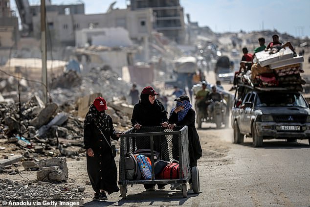 Residents move north along Al-Rashid Street with whatever belongings they managed to carry