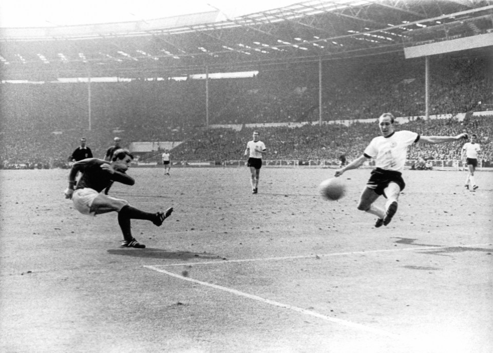England's Geoff Hurst kicking a soccer ball towards a goal.