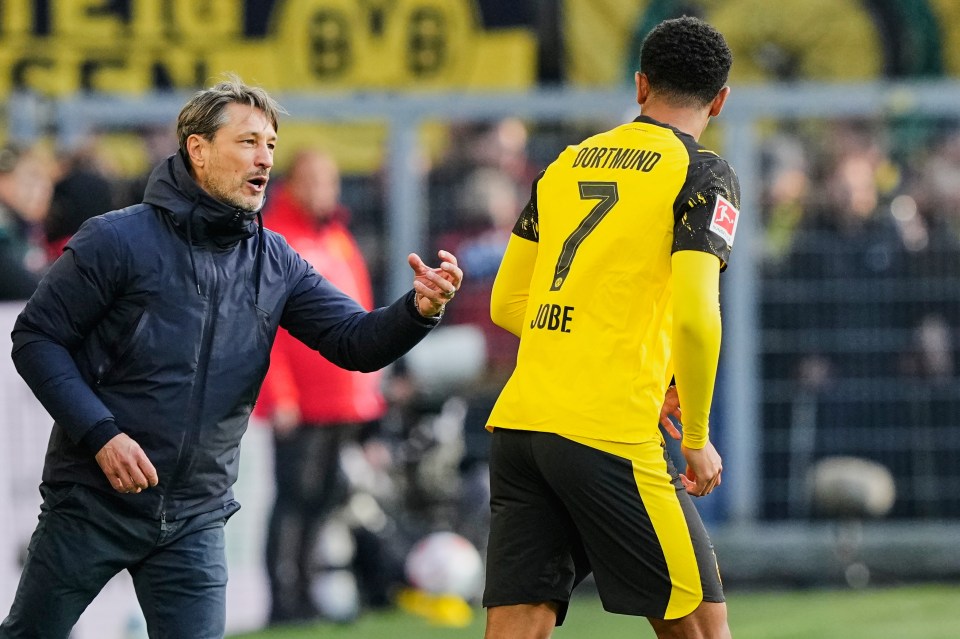 Dortmund's head coach Nico Kovac talks to player Jobe Bellingham during a soccer match.