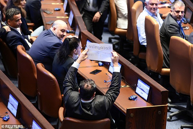 Knesset members Ayman Odeh and Ofer Cassif held up a sign that read, 'genocide'