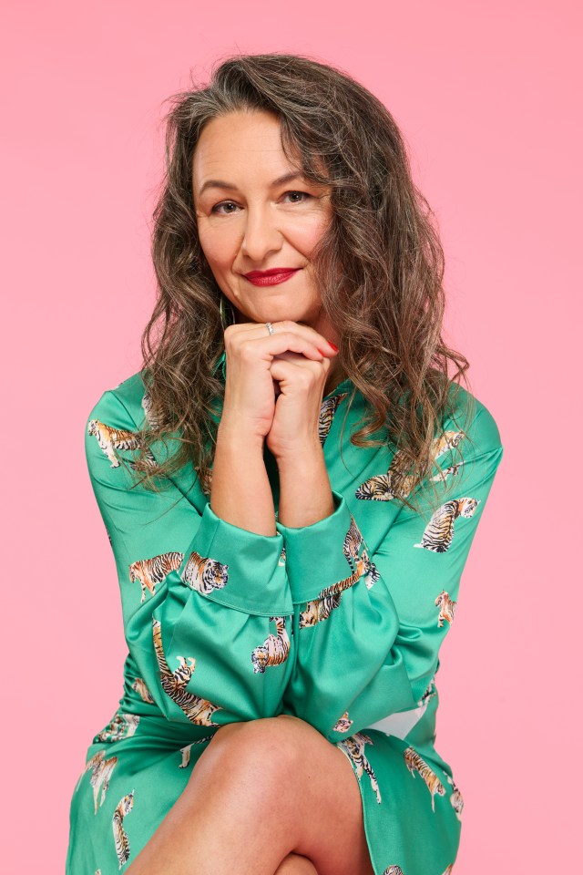 Carla Crivaro smiling, wearing a green dress with a tiger print, against a pink background.