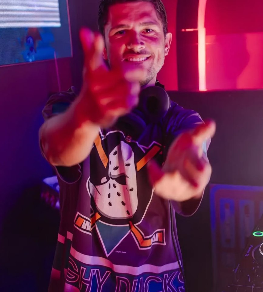 Jordan Davies DJing, wearing a Mighty Ducks jersey, and pointing at the camera.