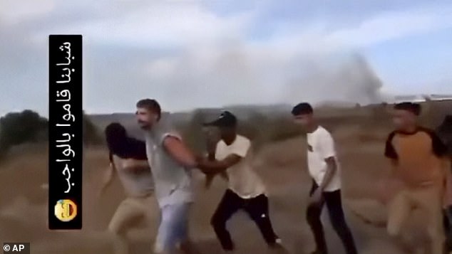 Avinatan, pictured second left, and Noa, not pictured, are seized by members of Hamas